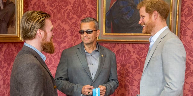 Britain's Prince Harry speaks with US Armed Forces veteran Ivan Castro (C) and British Armed Forces veteran Karl Hinett (L), who will run the Boston and London Marathons for the Heads Together Campaign..