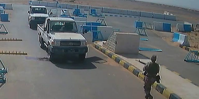 A still image taken from the surveillance video shows al-Tuwayha charging at the American soldiers with his gun drawn.