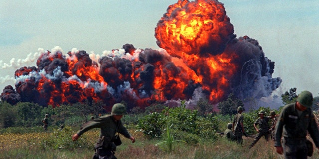 Napalm strike erupts in fireball near U.S. troops on patrol in 1966, South Vietnam. A few million people died during the war.