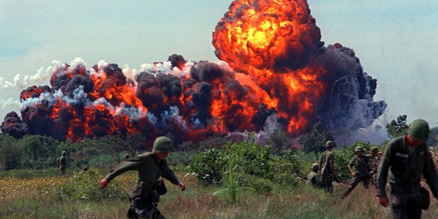 Napalm strike erupts in fireball near U.S. troops on patrol in 1966, South Vietnam. A few million people died during the war.