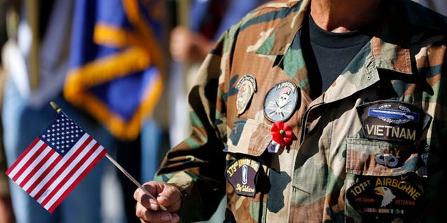 Nov. 11, 2013: A Vietnam veteran holds an American flag as he marches during the annual Veterans Day Parade in San Diego, Calif.