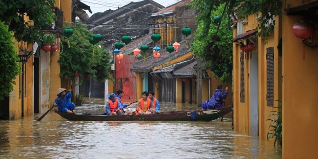 People ride a boat in flooded street in Hoi An, Vietnam, Monday, Nov. 6, 2017.