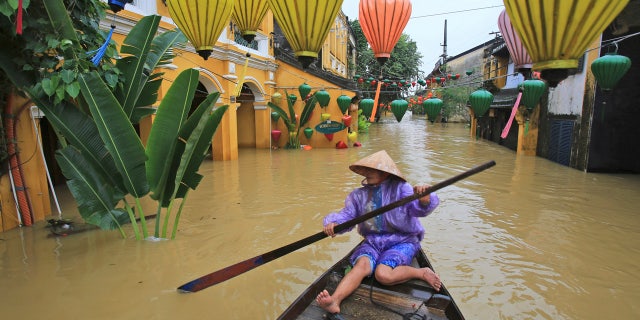 Nguyen Thi Vui paddles her boat in the flooded streets of Hoi An, Vietnam, Monday, Nov. 6, 2017.