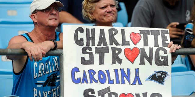 Carolina Panthers fans hold a sign as they watch the Panthers and Vikings warm up.