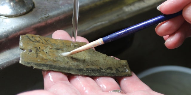 A tablet discovered at Vindolanda being cleaned (The Vindolanda Trust)