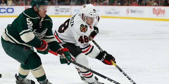 Chicago Blackhawks' Vinnie Hinostroza (48) controls the puck against Minnesota Wild's Erik Haula (56) in the second period of an NHL hockey game, Wednesday, Feb. 8, 2017, in St. Paul, Minn. (AP Photo/Stacy Bengs)