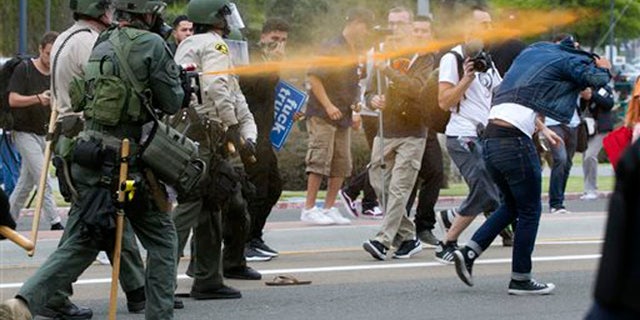 Police pepper sprayed protesters as they moved them down Harbor Drive in San Diego Friday, May 27, 2016. About a thousand Trump protesters demonstrated outside San Diego's convention center as Republican presidential candidate Donald Trump spoke inside to an enthusiastic crowd of supporters packed in tight. Several protesters were arrested. (John Gibbins/The San Diego Union-Tribune via AP) NO SALES; MANDATORY CREDIT