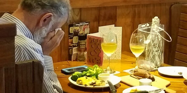 A man seen sitting at a restaurant dining with his wife's ashes.