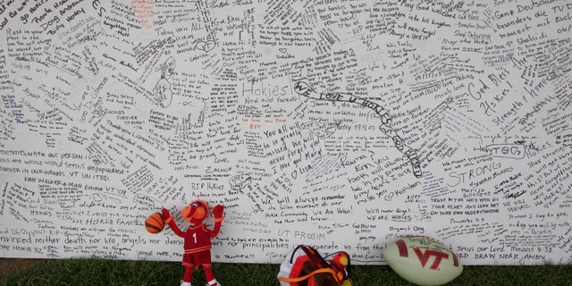 In this April 28, 2007 file photo, a memorial board sits under a tent with items that were placed in front of it, on the Drillfield on the Virginia Tech campus in Blacksburg, Va.