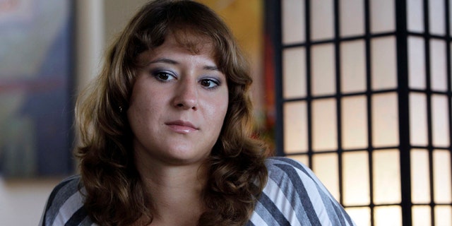 Aug. 24, 2010: Iuliia Bolgaryna sits for an interview in Surf City, N.C. Bolgaryna came to work on a J-1 visa at a souvenir store in Surf City, N.C. The store manager offered to let her and two other women from the Ukraine stay with him for $120 a week. But he wouldn't let them eat at the table, so they huddled together for meals on the floor. They worked loads of overtime but were only paid for 40 hours a week. (AP)