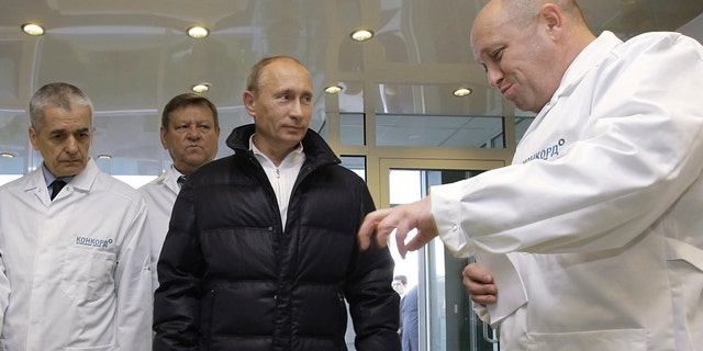 FILE - In this Monday, Sept. 20, 2010 file photo, businessman Yevgeny Prigozhin, right, shows Russian President Vladimir Putin, second right, around his factory which produces school means, outside St. Petersburg, Russia.  On Friday Feb. 16, 2018, Yevgeny Prigozhin along with 12 other Russians and three Russian organizations, were charged by the U.S. government as part of a vast and wide-ranging effort to sway political opinion during the 2016 U.S. presidential election.(Alexei Druzhinin, Sputnik, Kremlin Pool Photo via AP, File)
