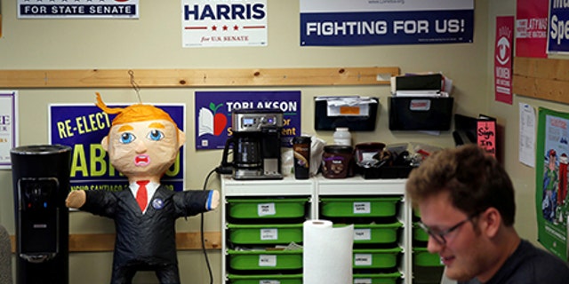 A pinata of Republican Presidential Candidate Donald Trump stands in front of various campaign signs decorating a wall as members of the Democratic Party of Orange County prepare to canvass a neighborhood in Orange, California May 15, 2016. Picture taken May 15, 2016. REUTERS/Patrick T. Fallon - RTSEKHI