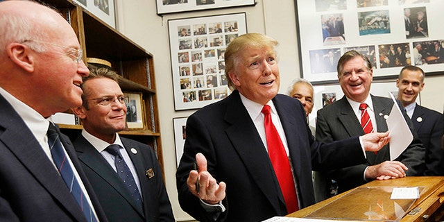 FILE - In this Nov. 4, 2015, file photo, New Hampshire Secretary of State Bill Gardner, left, watches at left as Republican presidential candidate Donald Trump reacts after filling out his filing papers to be on the nation's earliest presidential primary ballot at the Secretary of State's office in Concord, N.H. Gardner has been defending the request for detailed voter information from the Trump administration's commission on voter fraud. Gardner, a member of the commission, plans to provide publicly-accessible information, though critics argue state law allows the entire database to be provided only to political parties, political committees and candidates. Gardner is facing criticism for his decision, including from residents who inundated his office with calls. (AP Photo/Jim Cole, File)