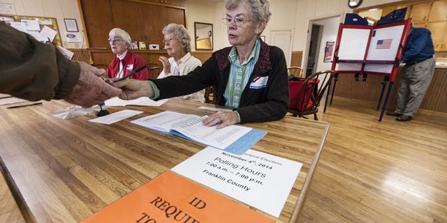 CENTROPOLIS TOWNSHIP, KS - NOVEMBER 4: Election worker Karen Witham checks voter identifications in the Richter Church November 4, 2014 in Centropolis Township, near Ottawa, Kansas. A tight race between independent candidate, Greg Orman (I-KS) and U.S. Sen. Pat Roberts (R-KS) brought voters to the polls in the Kansas midterm elections. (Photo by Julie Denesha/Getty Images)