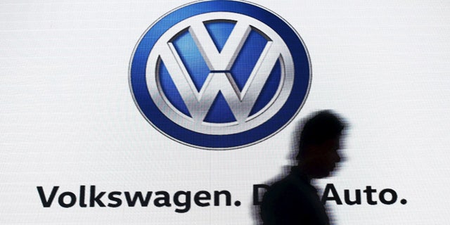 June 23, 2015: A man walks past a screen displaying a logo of Volkswagen at an event in New Delhi, India. (Reuters)