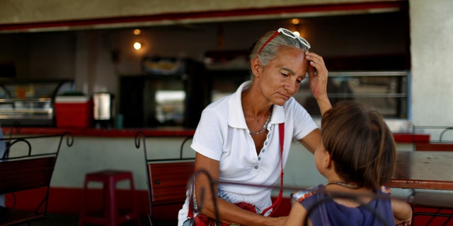 Zulay Pulgar, 43, in a coffee shop with her son Emmanuel, 4, after standing in line to buy cement in a hardware store in Punto Fijo, Venezuela November 17, 2016.