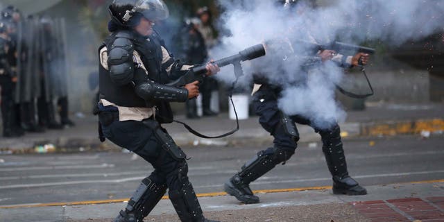 CARACAS, VENEZUELA - MARCH 06: Venezuelan national policemen fire teargas at anti-government demonstrators on March 6, 2014 in Caracas, Venezuela. Protesters continued to stage demonstrations nationwide against high inflation and crime. (Photo by John Moore/Getty Images)