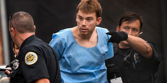 Travis Reinking, suspected of killing four people in a late-night shooting at a Waffle House restaurant, is escorted into the Hill Detention Center in Nashville.