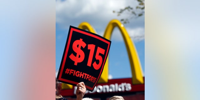 FILE - In this July 22, 2015 file photo, supporters of a $15 minimum wage for fast food workers rally in front of a McDonald's in Albany, N.Y. Millions of workers across the U.S. will see their pay increase as 19 states bump up their minimum wages as the new year begins. California, New York and Arizona are among the states with increases taking effect Saturday, Dec. 31, 2016 or Sunday, Jan. 1, 2017. New York state is taking a regional approach, with the wage rising to $11 in New York City, $10 in its suburbs and $9.70 upstate. (AP Photo/Mike Groll, File)