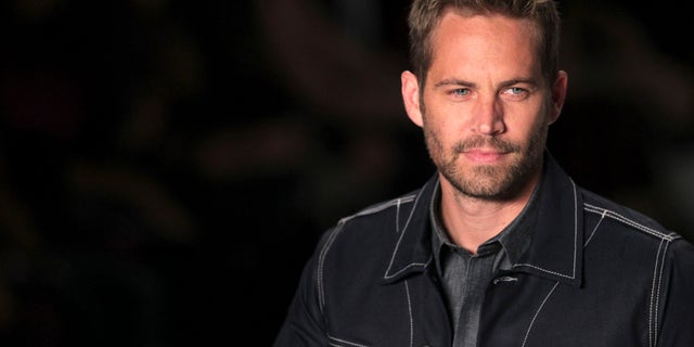 March 21, 2013. Paul Walker presents a creation from Colcci's 2013/2014 summer collection during Sao Paulo Fashion Week.