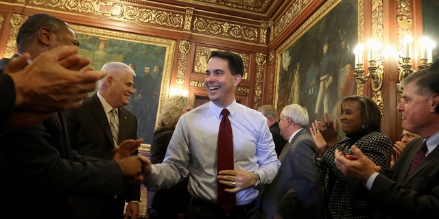 Nov. 5, 2014: Then-newly reelected Wisconsin Gov. Scott Walker is greeted by members of his staff and cabinet during a post-election day gathering at the Wisconsin State Capitol in Madison, Wis.