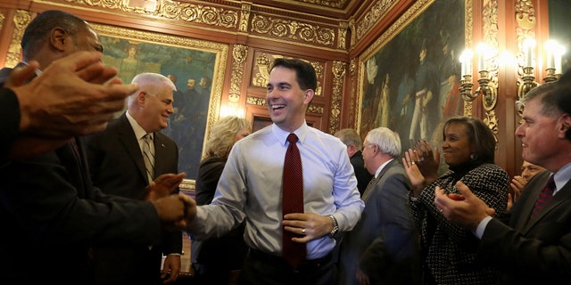 Nov. 5, 2014: Then-newly reelected Wisconsin Gov. Scott Walker is greeted by members of his staff and cabinet during a post-election day gathering at the Wisconsin State Capitol in Madison, Wis.