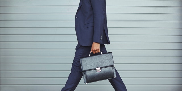 Legs of businessman in suit walking to work in the morning