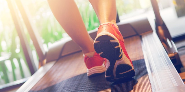 Close up on shoe athlete, Woman running in a gym on a treadmill concept for exercising and sunlight effect, fitness and healthy lifestyle