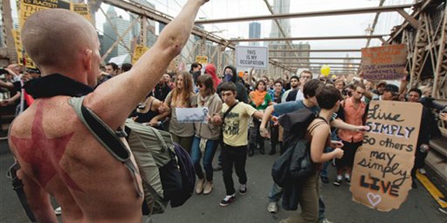 A large group of protesters affiliated with the Occupy Wall Street movement attempt to cross the Brooklyn Bridge, effectively shutting parts of it down, Saturday, Oct. 1, 2011 in New York.