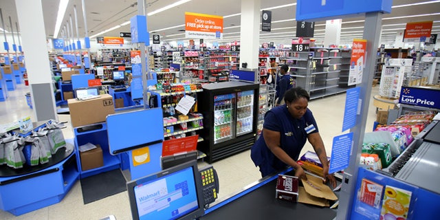 File photo - A worker prepares the check-out area at a Walmart Super Center prior to its opening in Compton, California, U.S., Jan. 10, 2017. (REUTERS/Mike Blake)