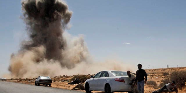 March 7: Smoke raises following an airstrike by Libyan warplanes near a checkpoint close to the anti-Libyan Leader Muammar al-Qaddafi rebels checkpoint in the oil town of Ras Lanouf, eastern Libya. (AP)