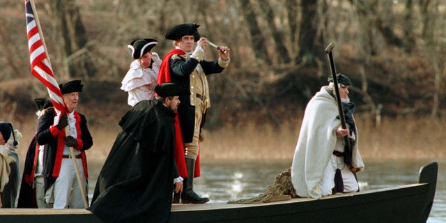 Revolutionary War reenactors cross the Delaware River between Pennsylvania and New Jersey.