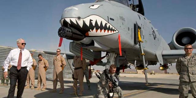 FILE 2008: Then-US Secretary of Defense Robert Gates, left, greets the crew and looks over an A-10 "Warthog," a close support aircraft, during an unannounced visit to Bagram Airfield.