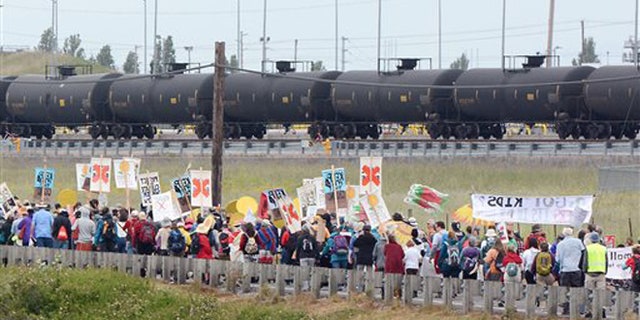 Anti-oil protestors walk past the Tesoro refinery rail yard in Anacortes, Wash., on Saturday, May 14, 2016. The protests are part of a series of global actions calling on people to "break free" from dependence on fossil fuels. (Scott Terrell/Skagit Valley Herald via AP)