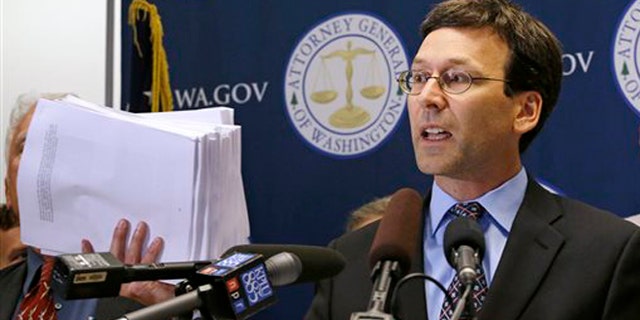 Sept. 2, 2015: Washington Attorney General Bob Ferguson holds up what he said were 19 reports and studies done since 1992 of vapors escaping from tanks at the Hanford Nuclear Reservation, at a news conference in Seattle.