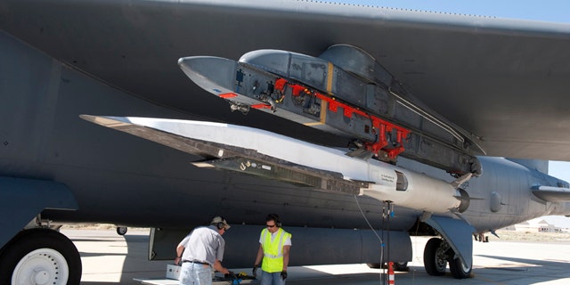 Ground crew members make the final checks to the X-51A Waverider scramjet, which is affixed to an Edwards B-52H Stratofortress, before the Waverider's June 13 flight test.