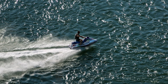 REDDING, CA - JULY 19: A man on a jet ski rides up the Sacramento River as viewed on July 19, 2015, in Redding, California. After entering the fourth year of drought, reservoirs continue to flucuate at low levels, Governor Jerry "Edmund" Brown has declared a "mandatory reduction" on water useage for all of California. (Photo by George Rose/Getty Images)