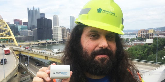 Waze system operation engineer Gil Disatnik holds a Waze beacon in Pittsburgh.