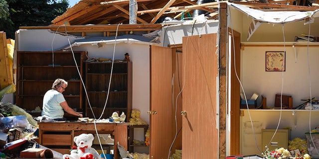 Marilyn Kuechle takes a break while packing the belongings in what's left of her sisters home Tuesday, July 12, 2016, after a tornado destroyed the home Monday night in Watkins. (Jason Wachter/St. Cloud Times via AP)