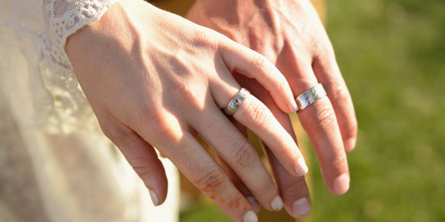 The hands of bride and groom are seen in Indio, California, April 11, 2015.