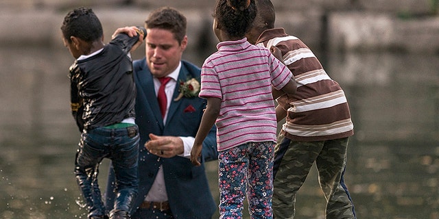 A groom in Canada is being called a hero after he saved a little boy from drowning during his wedding photo shoot 