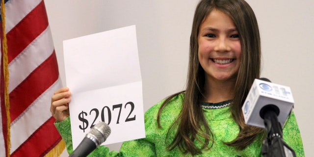 FILE 2015: Student Shania Sommer of Palmer, Alaska, announces that nearly every Alaskan will receive $2,072 from the year's oil dividend check during a news conference in Anchorage, Alaska.