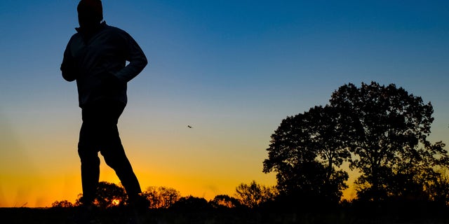 Nov. 22, 2016: In this file photo, a runner is silhouetted against the sunrise on his early morning workout near Arlington National Cemetery.