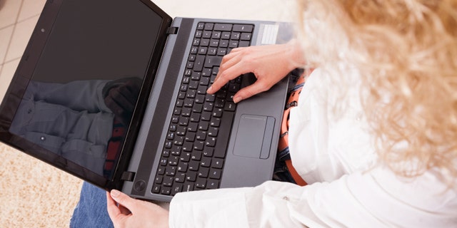 Portrait of a pretty young girl working on her laptop at home