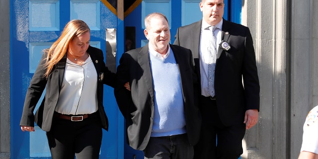 Harvey Weinstein smiled as two officials escort him, handcuffed, to a car after he was charged with rape, criminal sex act, sex abuse and sexual misconduct in incidents on two separate women.