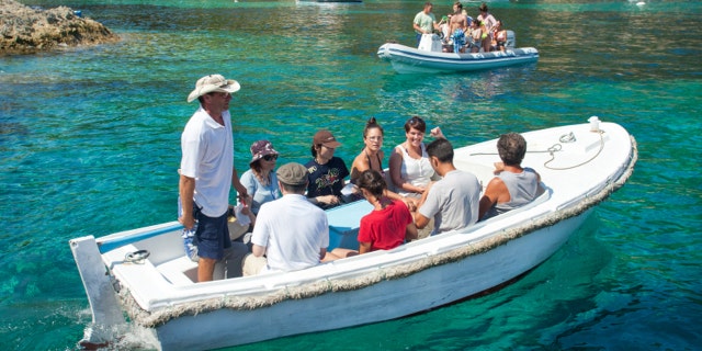 VIS, CROATIA - AUGUST 20, 2012: Tourists on boat to the Blue Hole cave.