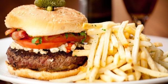 Bacon Cheeseburger with french fries served in restaurant