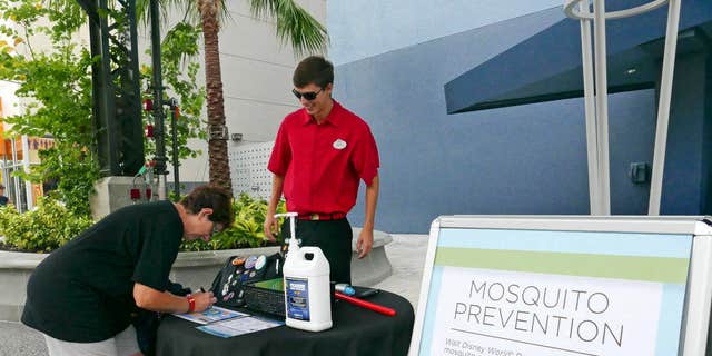 A tourist stops by a station giving out free mosquito repellant at Disney Springs in Lake Buena Vista, Fla. on Tuesday Sept. 13, 2016.