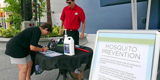 A tourist stops by a station giving out free mosquito repellant at Disney Springs in Lake Buena Vista, Fla. on Tuesday Sept. 13, 2016.