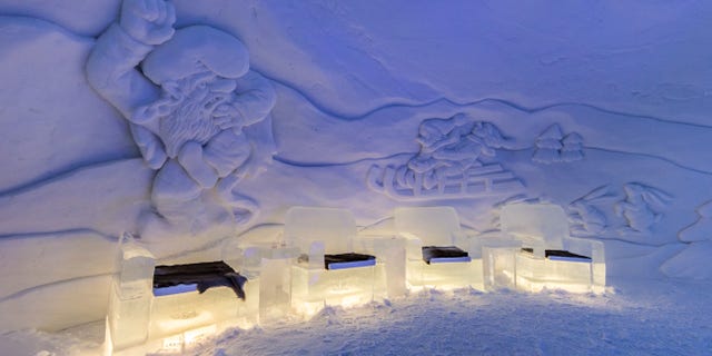 D48JJ0 Interior of the Kirkenes Snowhotel, Norway, showing furniture made from ice and snow sculptures on the wall